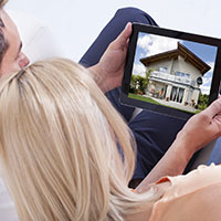 Couple looking at houses on tablet.